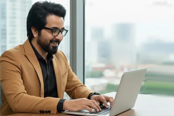 Fawad Mohsin working at a laptop by an office window